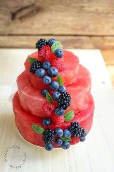 a watermelon cake with berries and mint on top