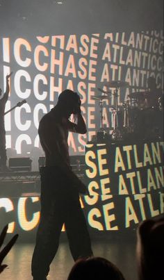 a man standing on top of a stage next to a microphone in front of a crowd