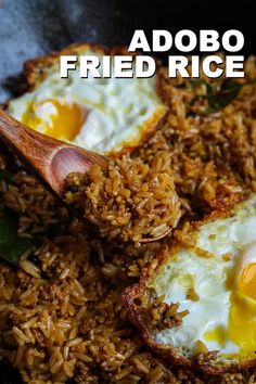 fried rice and eggs in a skillet with a wooden spoon on the side that says, adobo fried rice