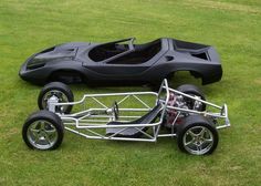 an electric car is parked on the grass in front of a lawnmower that's attached to it