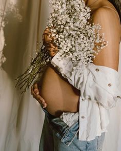 a pregnant woman holding a bouquet of flowers