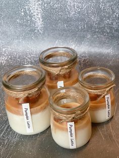 four jars filled with food sitting on top of a table