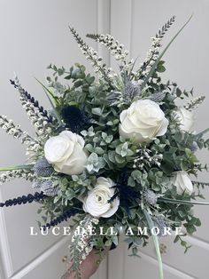 a bouquet of white roses and greenery in front of a door with the words luscula allamore written on it