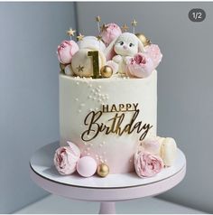 a birthday cake with pink flowers and teddy bears on top is shown in front of a gray background