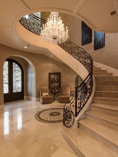 an elegant staircase with chandelier and marble floors