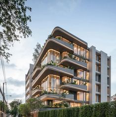 an apartment building with many balconies and plants on the balconys at dusk