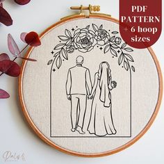 a cross stitch pattern with the outline of a bride and groom standing in front of a floral frame