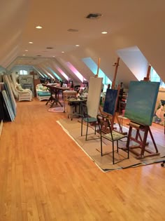 an art studio with lots of easels and paintings on the floor in front of them