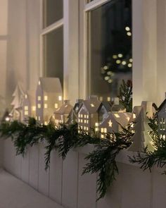 a window sill decorated with christmas lights and greenery