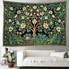 a large tapestry hanging on the wall next to a white couch and potted plant