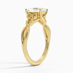 a yellow gold engagement ring with an oval cut diamond in the center and leaves on the side