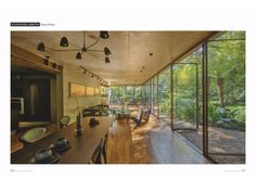 an open kitchen and dining room with wood flooring, large glass doors to the outside