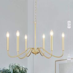 a gold chandelier with six lights hanging from the ceiling