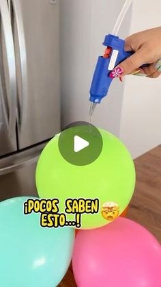 a person is spray painting balloons on a table with an object in front of them