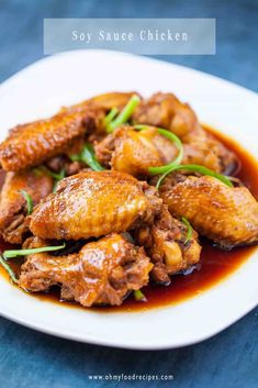 chicken wings in sauce on a white plate with the words soy sauce chicken above it