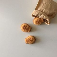 three cookies sitting on top of a table next to a bag