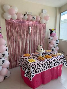 a table topped with cake and desserts next to balloons