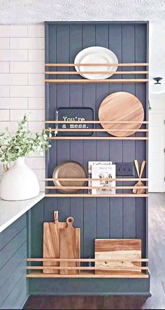 the shelves in this kitchen are organized with cutting boards, plates and utensils