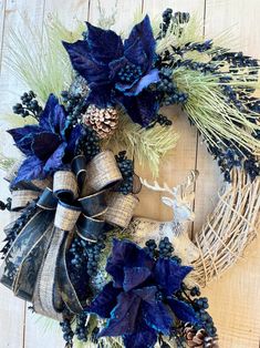 a wreath with blue flowers and pine cones