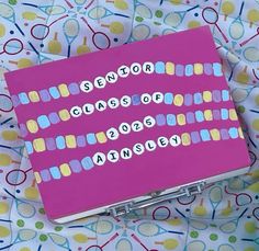 a pink box with words on it sitting on top of a colorful tablecloth covered surface