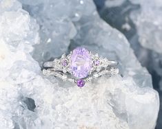 a ring with an amethorate and purple stones sits on top of ice