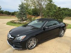 a black car is parked in the driveway