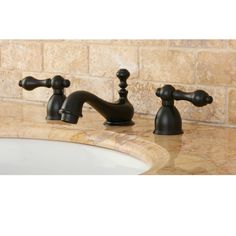 two black faucets sitting on top of a marble counter