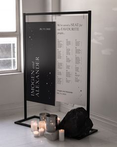 candles are placed on the floor next to a sign and some rocks in front of it