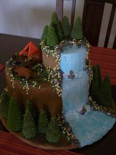 a cake made to look like a waterfall with trees and rocks around it on a table