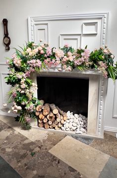 a fireplace decorated with flowers and logs