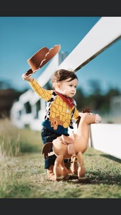 a little boy riding on the back of a toy horse