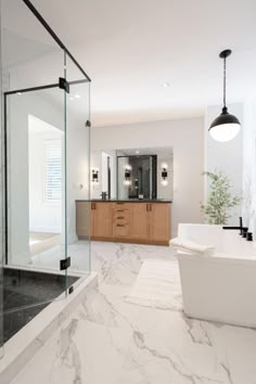 a bathroom with marble flooring and walls, along with a large bathtub in the center