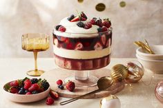 a dessert with strawberries, raspberries and cream in it on a table