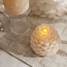 two candles sitting on top of a table next to each other