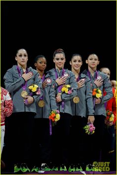 the women's gymnastics team poses with their gold medals