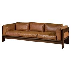 a brown leather couch sitting on top of a wooden frame