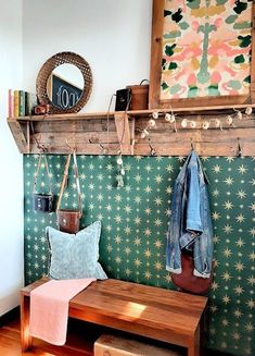 a wooden bench sitting in front of a wall mounted coat rack with hooks on it