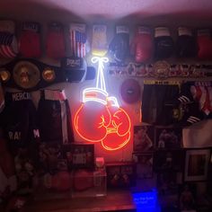 there is a neon sign in the corner of this room with boxing gloves on it