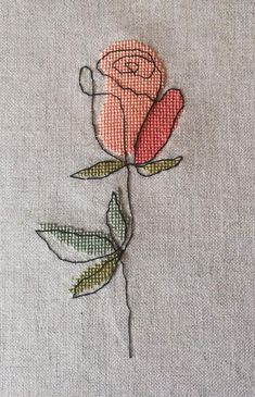 a rose is embroidered on the side of a piece of cloth