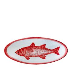 a red and white plate with a fish design on the bottom, in front of a white background