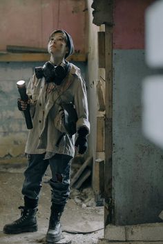 a man standing in an abandoned building holding a candle