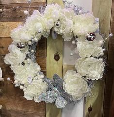 a wreath with white flowers and silver decorations