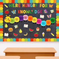 there is a very colorful bulletin board on the wall in the classroom with flowers and fruit