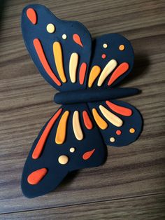 a blue and orange butterfly sitting on top of a wooden table