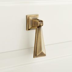 a close up of a door handle on a white cabinet with wood grained handles