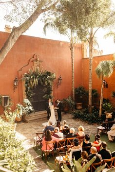 an outdoor ceremony with people sitting in chairs