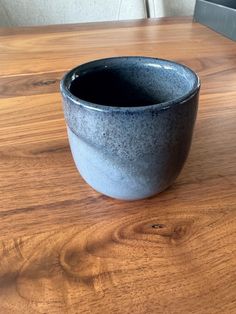 a black bowl sitting on top of a wooden table