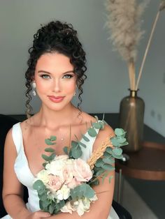 a woman sitting in a chair holding a bouquet