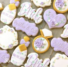 some decorated cookies are laying on a table with the names and date written on them