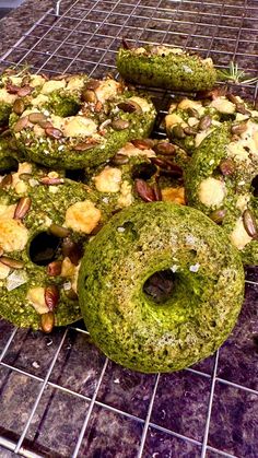 a bunch of doughnuts that are covered in green and brown stuff on a rack